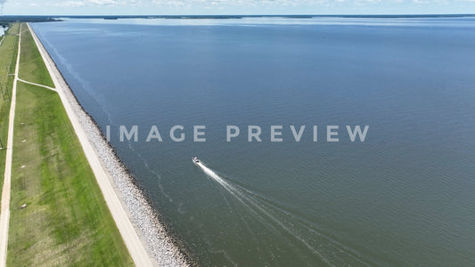 Stock photo 4k Still Frame - Lake Marion, SC boat motoring by earthen dam