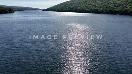 4k Still Frame - Canadice Lake, NY aerial of Finger Lake with sunshine on water