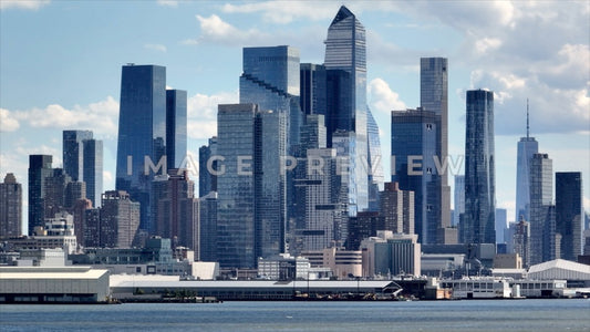 Photo - New York City, NY Glass towers reflecting blue sky and white clouds