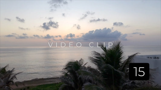 CLIP 15 - Isla Mujeras, Mexico low flight over rooftop past palms to sun rising