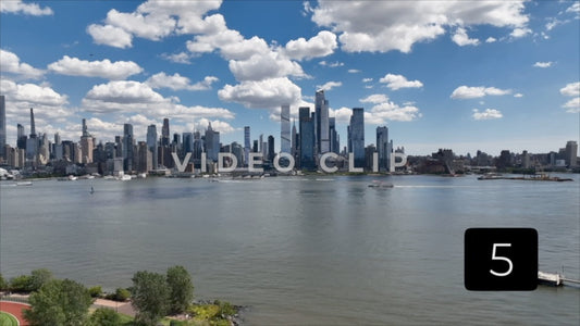 CLIP 5 - New York, NY Vol 2. - Tour boat motors by city skyline on Hudson River with blue sky and fluffy clouds