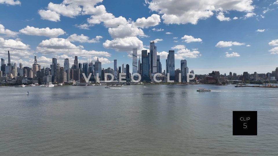 CLIP 5 - New York, NY Tour boat motors by city skyline on Hudson River with blue sky and fluffy clouds