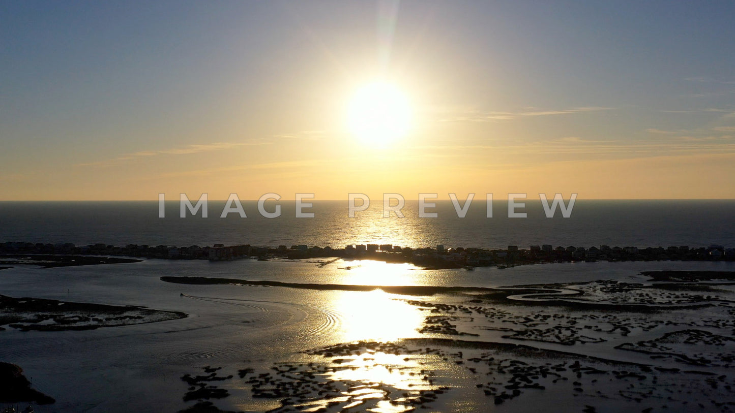 4k Still Frame - Murrells Inlet, SC sunrise as boat motors in waterway around marsh grass