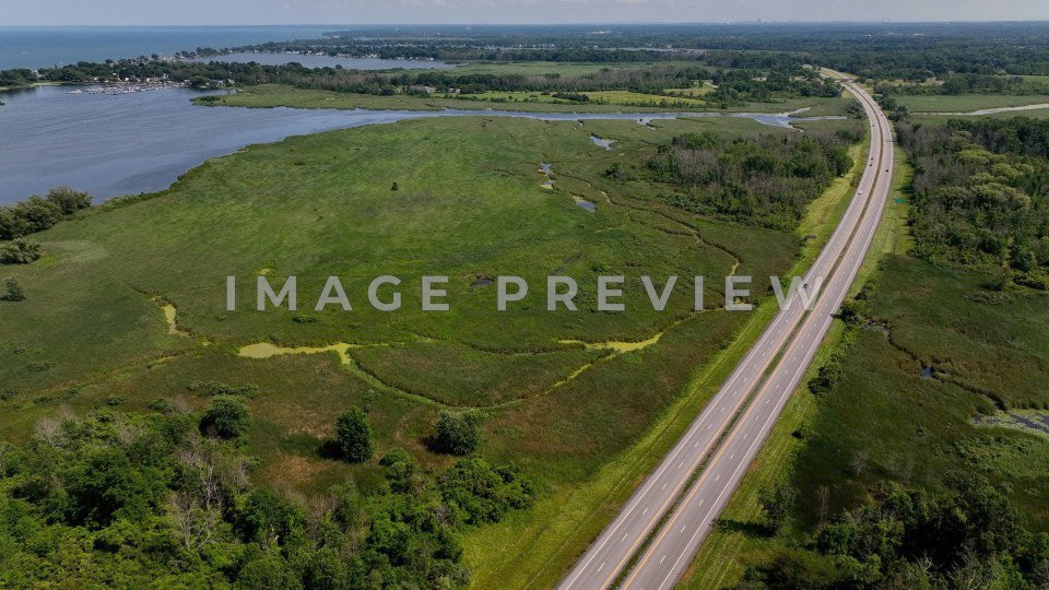 4k Still Frame - Braddock Bay, NY traffic driving by scenic wetland wildlife conservation area