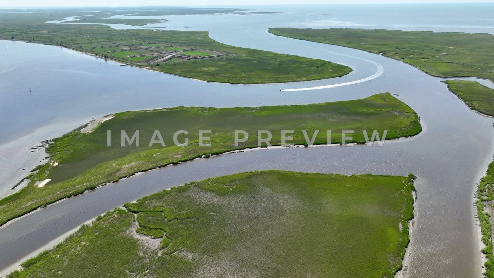 4k Still Frame - McClellanville, SC boat motors through inlet past tidal marshland to Intracoastal Waterway