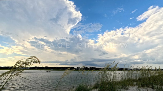 4k Still Frame - Pawleys Island, SC Fisherman motors across North Inlet past sand dunes