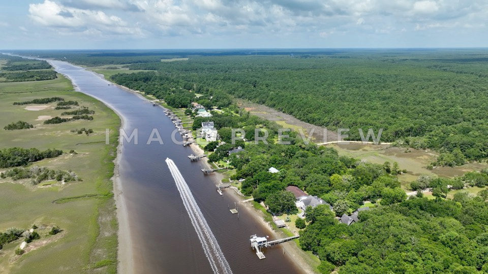 4k Still Frame - McClellanville, SC aerial view of boat motoring past homes on Intracoastal Waterway