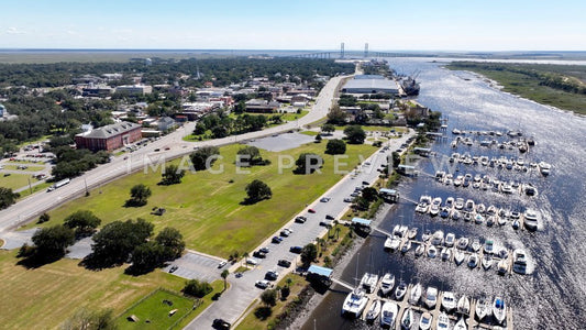Brunswick, GA Green public park beside marina with suspension bridge on horizon