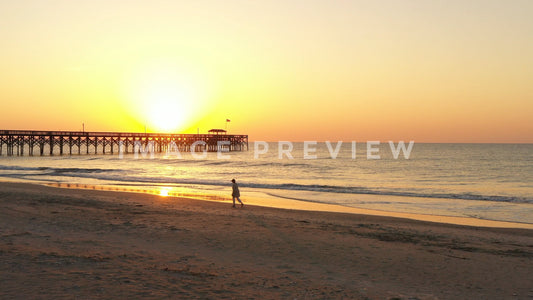 stock photo sunrise beach walker by pier
