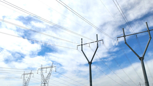 stock photo electric power towers against blue sky with clouds