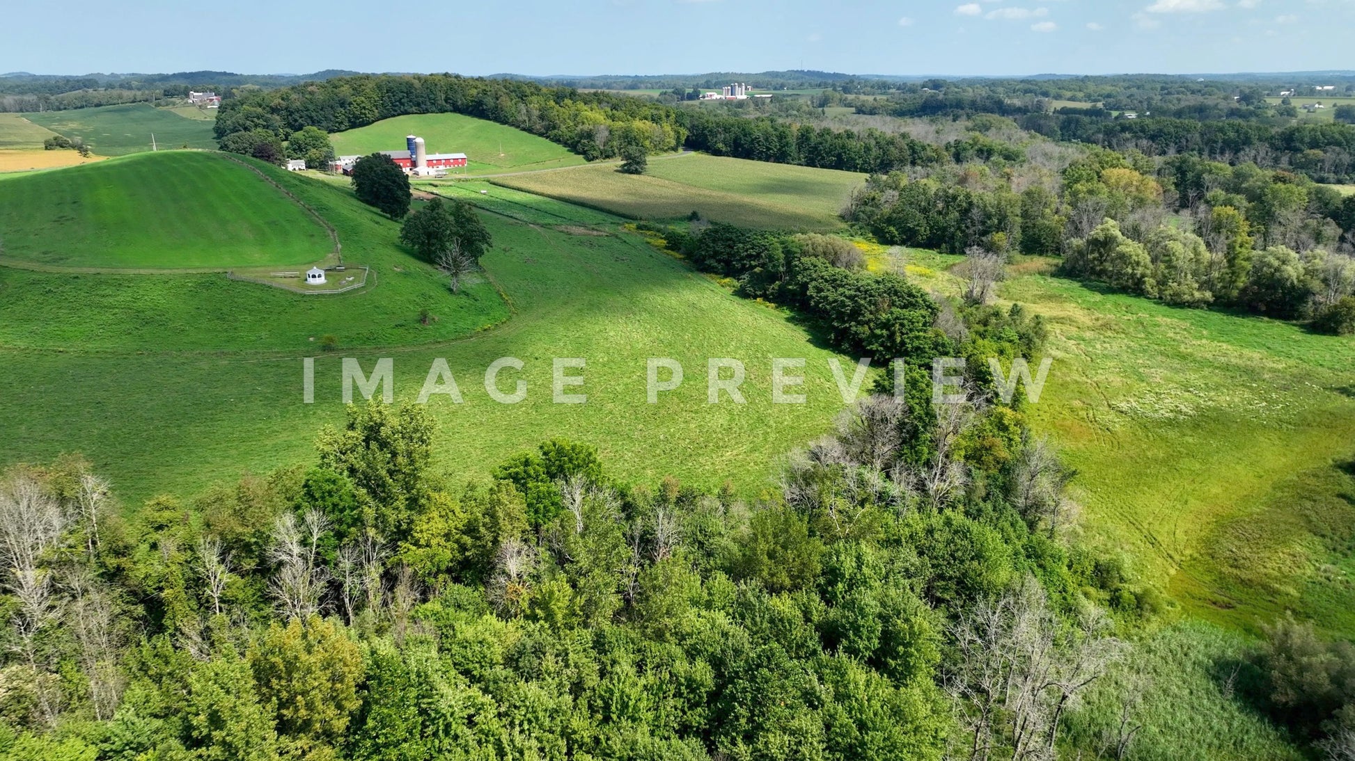 stock photo Aerial landscape with green rolling hills and farmhouse in New York State