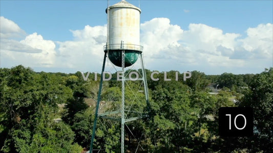 CLIP 10 - Montezuma, GA rising up past old watertower towards blue sky and clouds