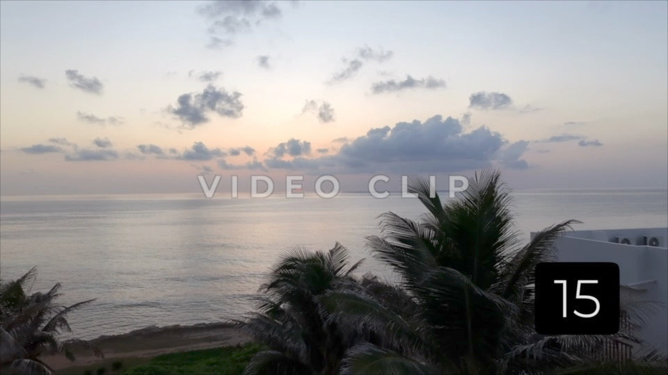 CLIP 15 - Isla Mujeras, Mexico low flight over rooftop past palms to sun rising