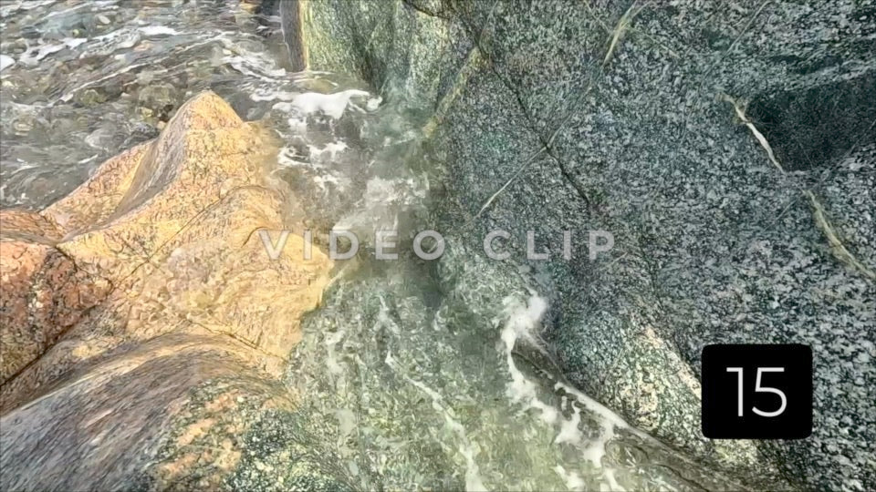 CLIP 15 - Slow motion - coastal beach with surf tumbling over boulders on shore