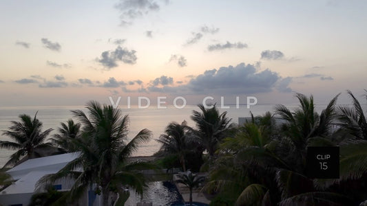 CLIP 15 - Isla Mujeras, Mexico low flight over rooftop past palms to sun rising