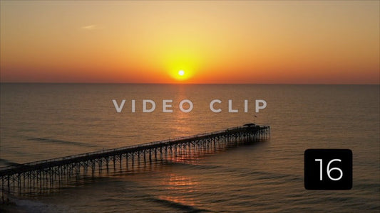 CLIP 16 - Pawleys Island, SC bird flies in front of camera at sunrise with fishing pier