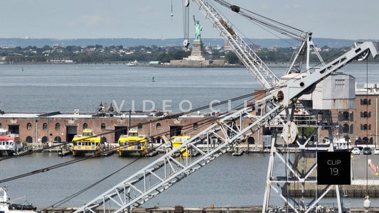 CLIP 19 - New York, NY aerial rising up past shipping cranes on Staten Island to view Statue of Liberty