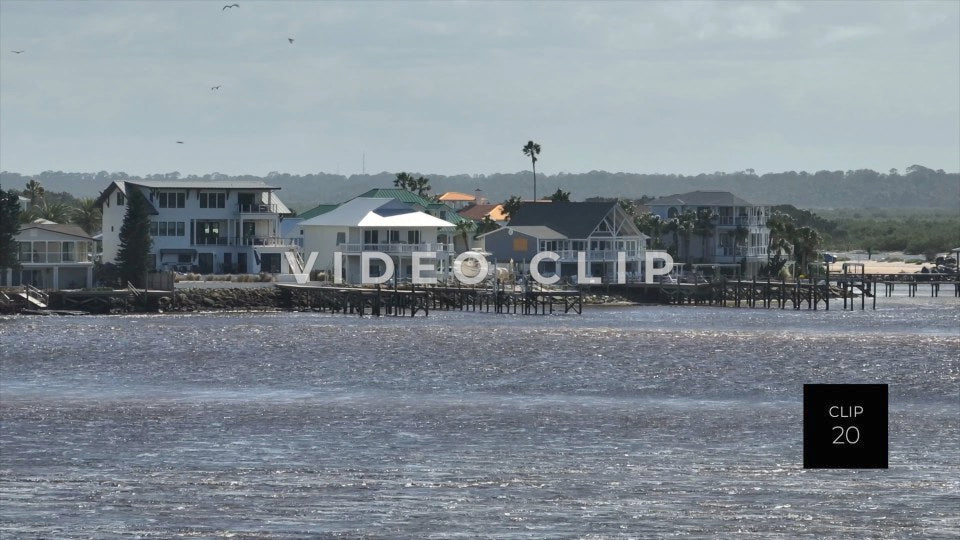 CLIP 20 - St Augustine, Florida shorebird dives into water in front of houses in Matanzas inlet