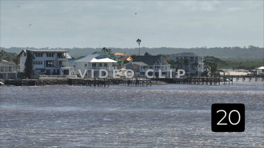 CLIP 20 - St Augustine, Florida shorebird dives into water in front of houses in Matanzas inlet