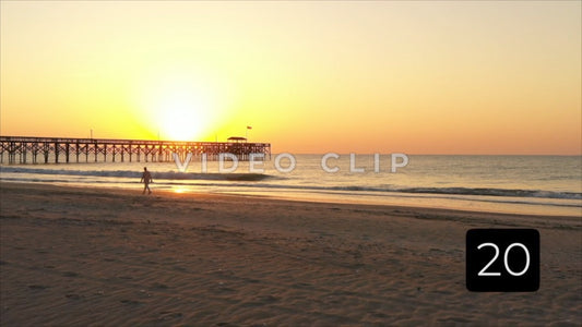 CLIP 20 - Pawleys Island, SC beach walker beside fishing pier at sunrise