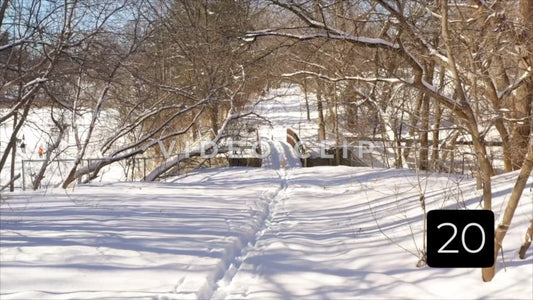 CLIP 20 - Winter Vol. 5 - Snow covered walking trail with creek bridge in public park