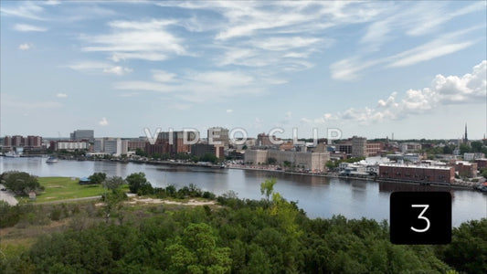 CLIP 3 - Wilmington, NC city skyline under blue sky and clouds beside Cape Fear River