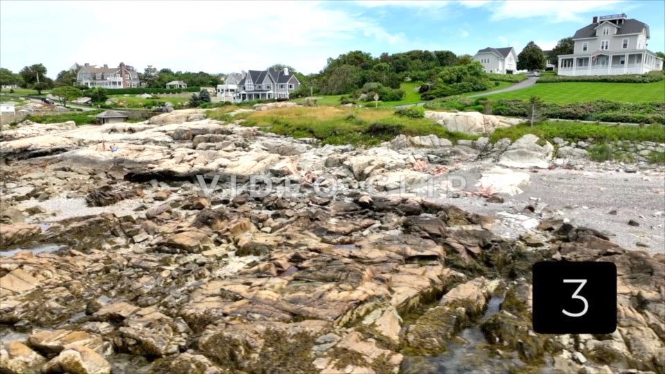 CLIP 3 - Boston, MA rising up over rocky coastline with houses on hillside