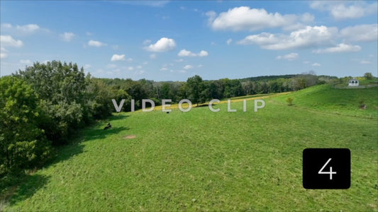 CLIP 4 - Close flight past trees to reveal green pasture with gazebo on hillside in New York State countryside