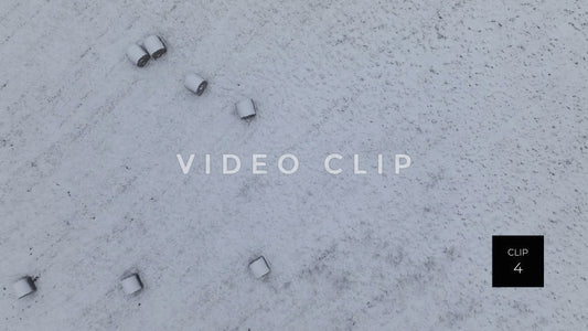 CLIP 4 - Lowering down into snow covered pasture with hay bales in Winter