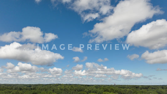 4k Still Frame - Puffy clouds over green landscape