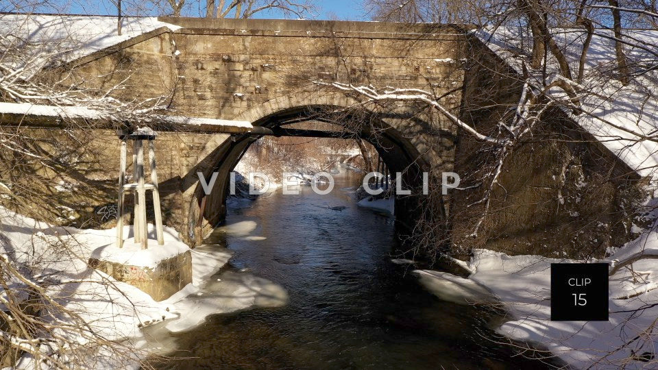 CLIP 15 - Arched stone train bridge over gentle running creek in Winter