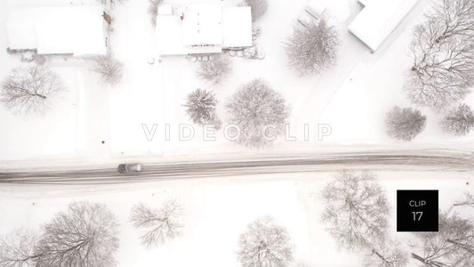 CLIP 17 - Homes and street in Winter snow as car passes by