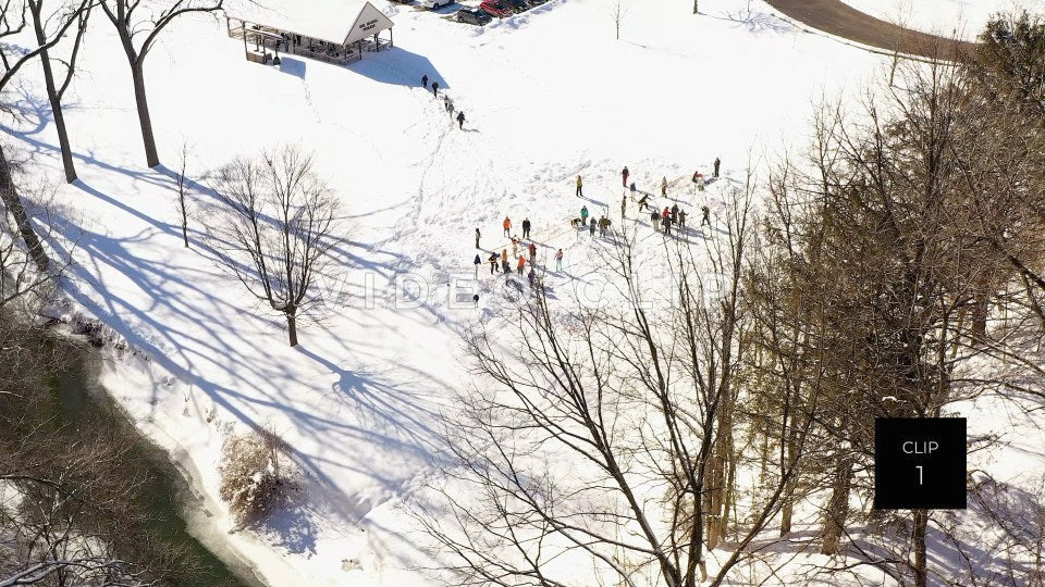 CLIP 1 - People playing outdoors in park during Winter with snow