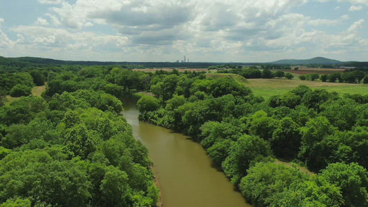Video - Flying over river and trees to reveal Etowah Indian Mounds State Historic Site in Cartersville Georgia