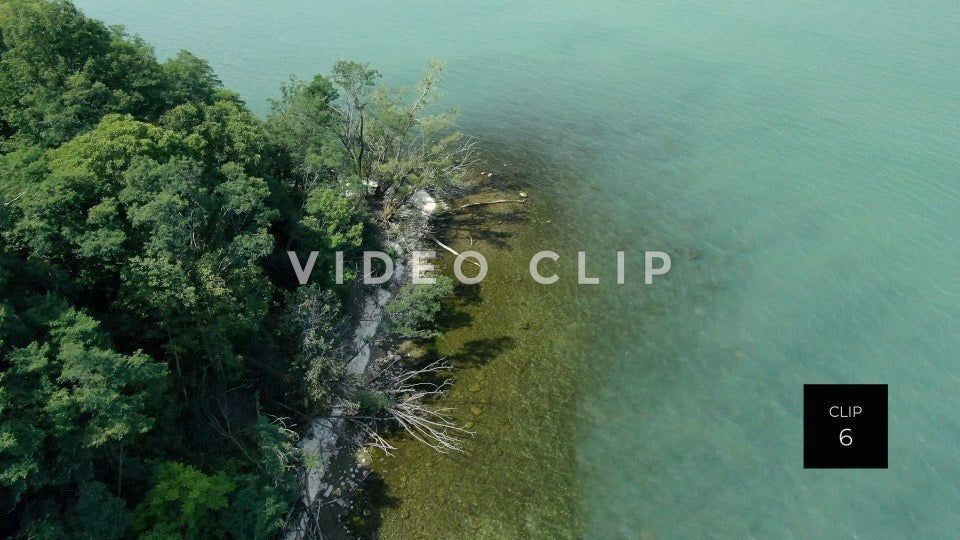 CLIP 6 - Lake Ontario Webster, NY shoreline with clear water, trees and sand