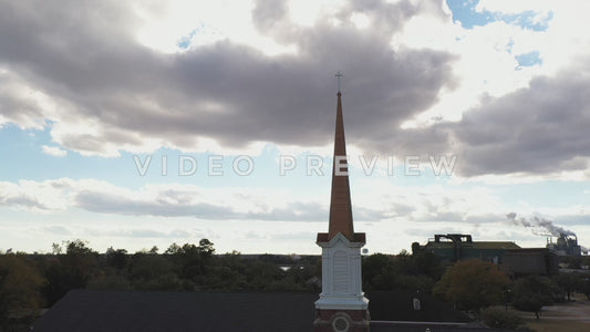 Video - Church steeple with dramatic sun and clouds over small town