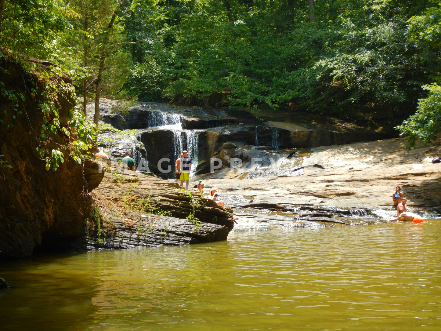 Photo - People enjoy a day by a waterfall during summer