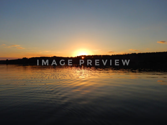 Photo - Sunset over calm lake water