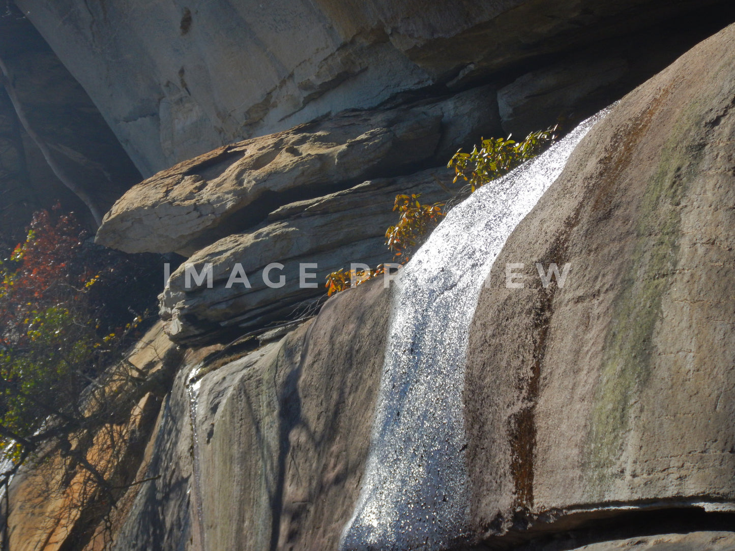 Photo - Rock formations on mountainside with water in sunlight