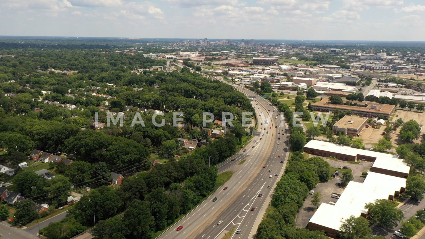 4k Still Frame - Cars travel down Interstate 95 past urban homes towards city of Richmond, Virginia on horizon