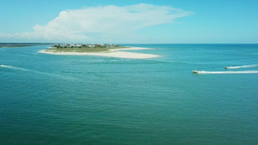 Video - Gorgeous aerial of boats entering Murrells Inlet past vacation beach houses in South Carolina